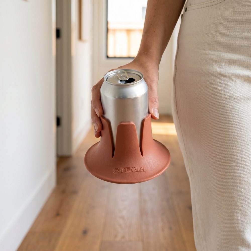A hand sliding an aluminium can down into the fins of a Steadi.